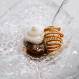 brownie topped with ice cream and a caramel sauce
