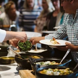 chefs serving food to guests during the cooking demonstration 