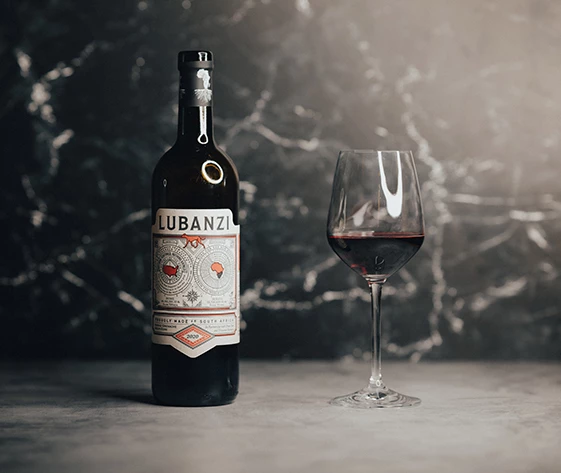 a bottle of wine next to a glass of wine
