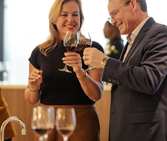 a man and woman holding wine glasses
