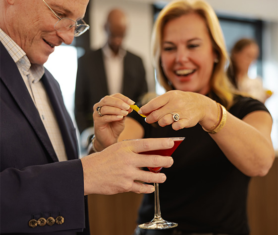 a man and woman holding a glass of liquid