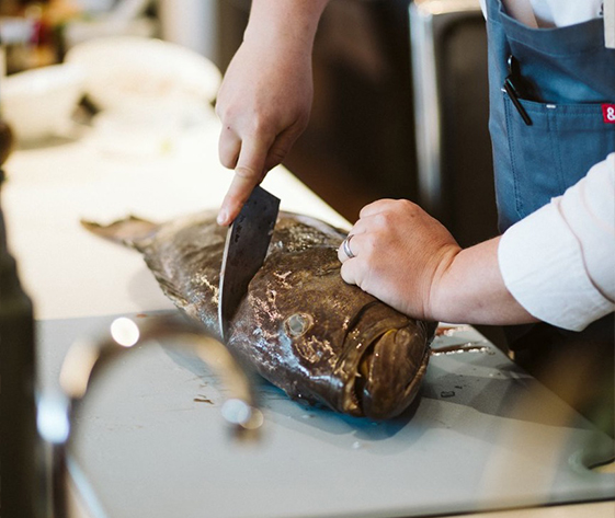 a person cutting a fish