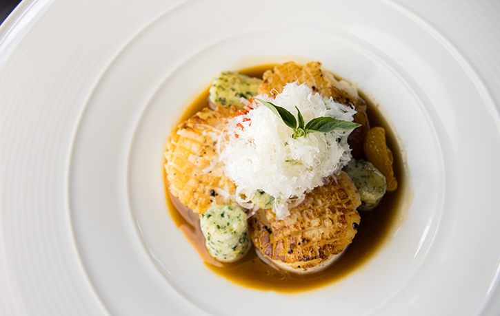 a plate of food with gravy and a leaf