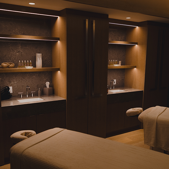 a massage room with a bed and shelves