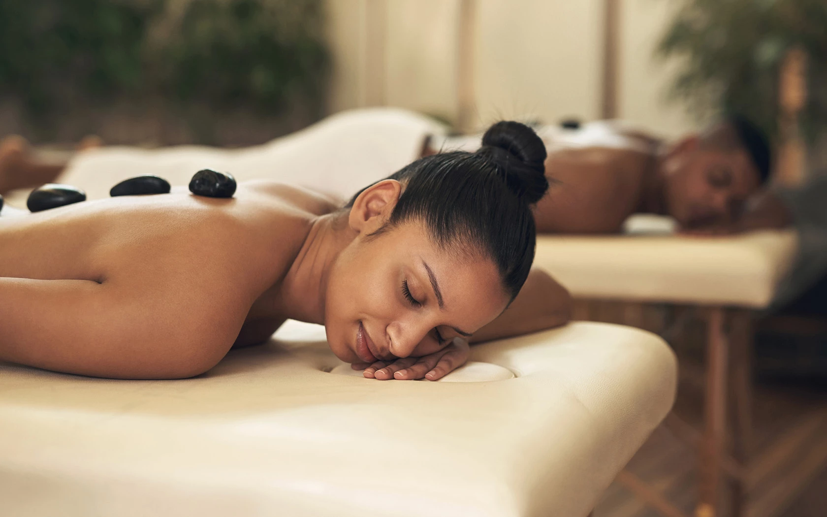 view of a couple laying on their stomachs receiving a hot stone treatment