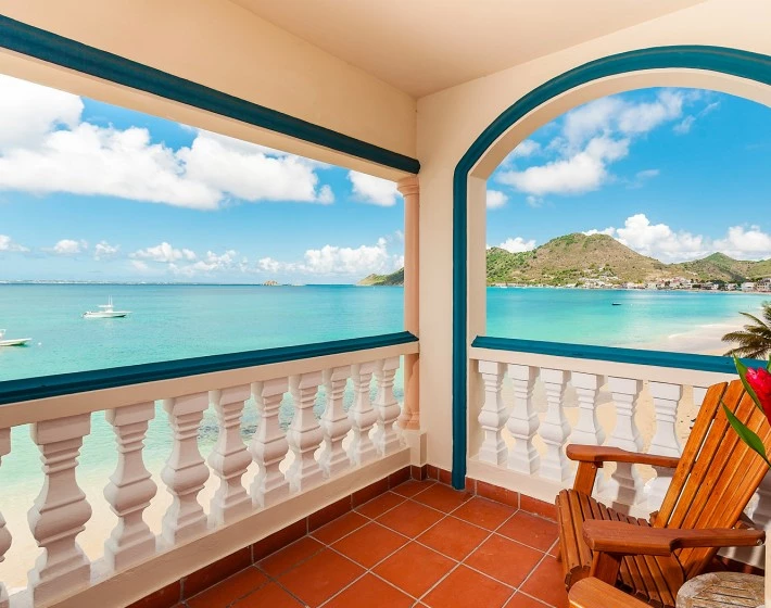 a deck with chairs and a body of water in the background