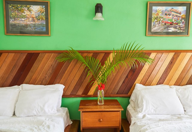 spacious guest room close up on nightstand between two beds, colorful peaceful room and wooden decor