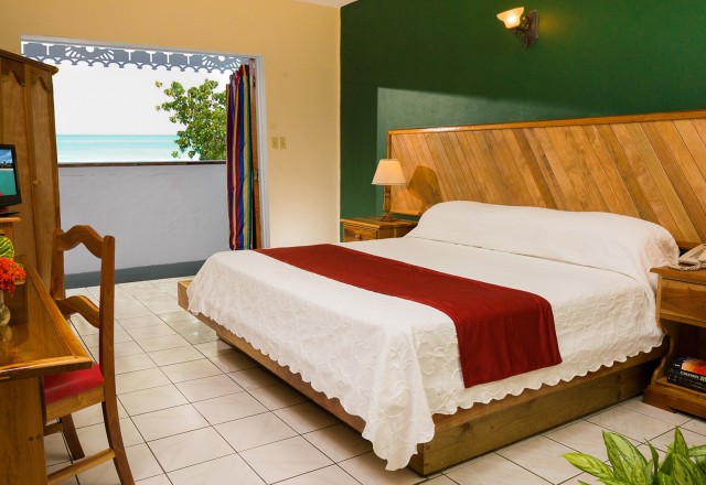 open and airy king size guest room with ocean view from balcony