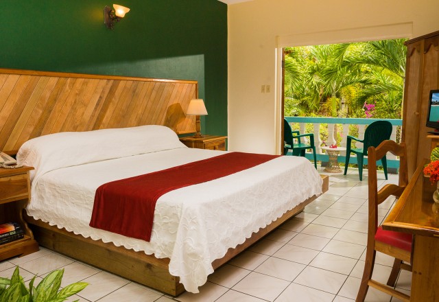 open and airy bedroom with crisp white linens garden view from balcony
