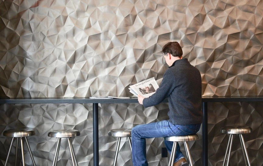 a person reading the newspaper at a bar