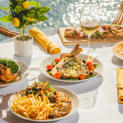 a table with plates of food and wine glasses
