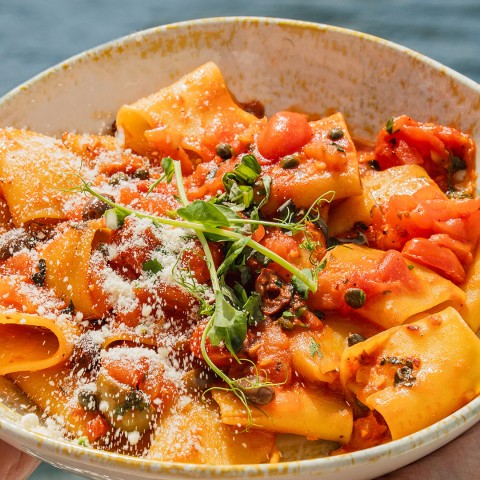 a bowl of pasta with cheese and herbs