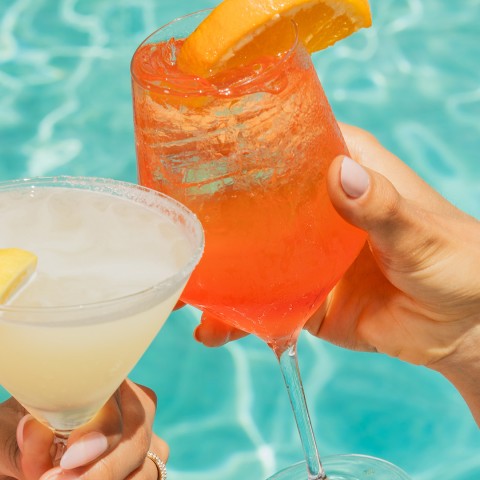 a pair of hands holding drinks