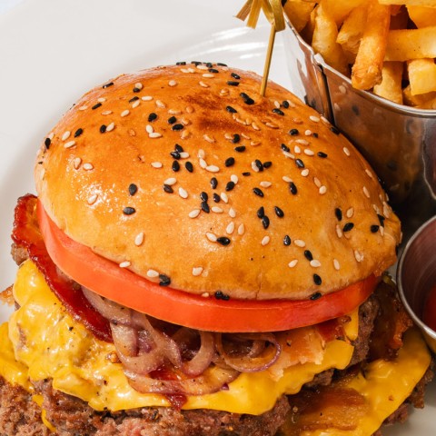a cheeseburger with a bowl of fries