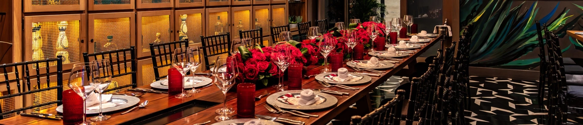 a table with red roses and glasses