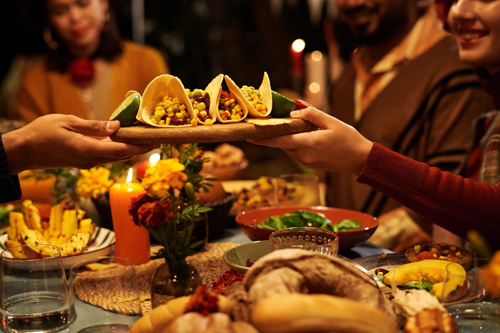 a person holding tacos over a table