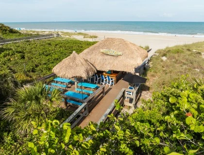 a hut with chairs and tables on a beach