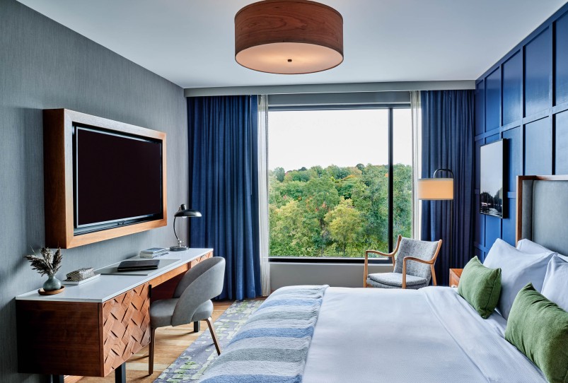a room with a bed and a desk and a television