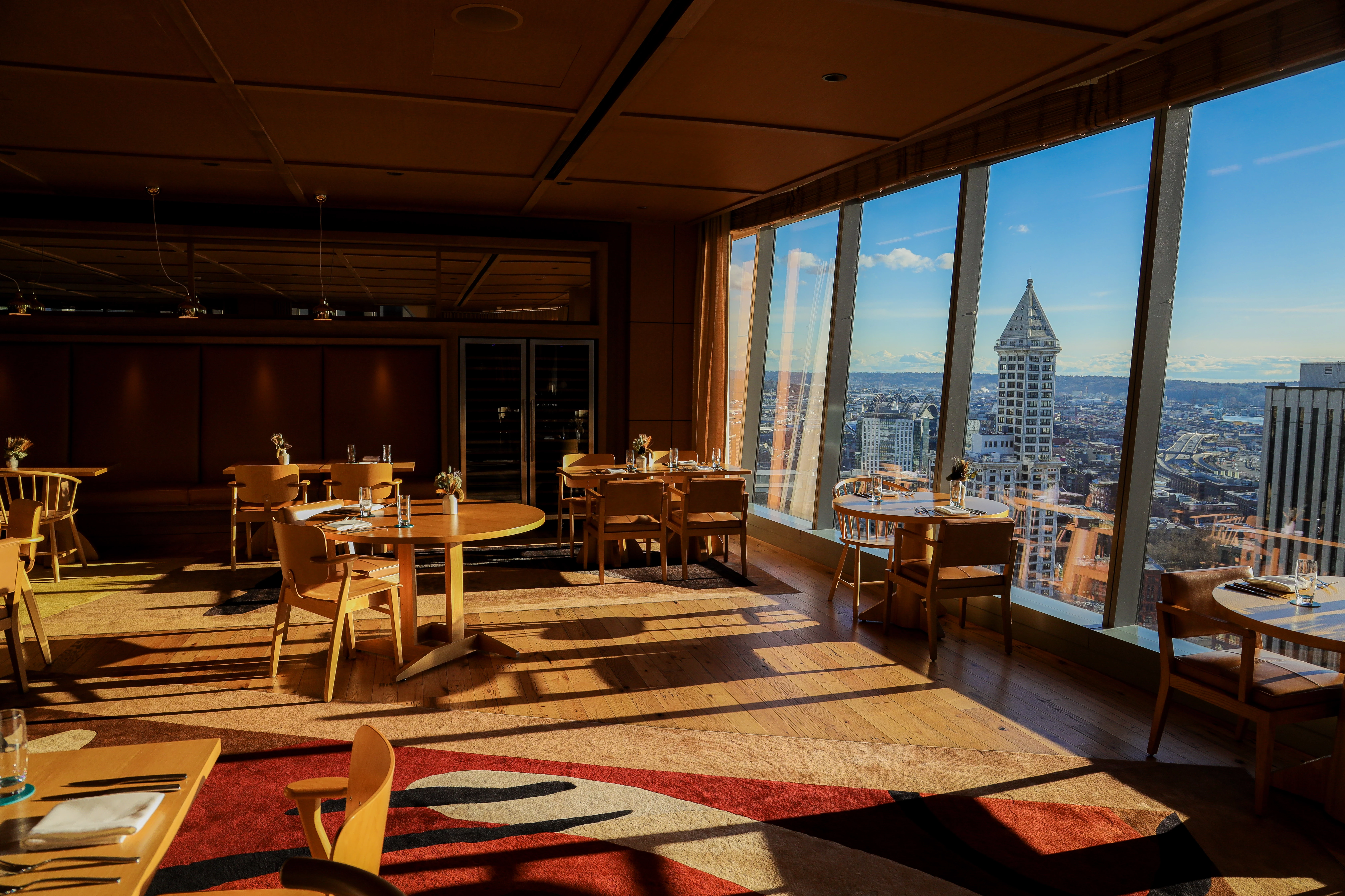 a room with tables and chairs and a view of a city
