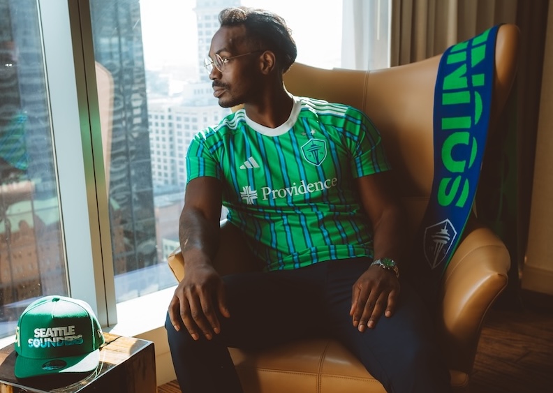 a man sitting in a chair looking out a window