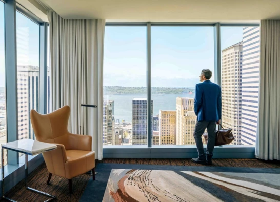 a man standing in a room looking out a window