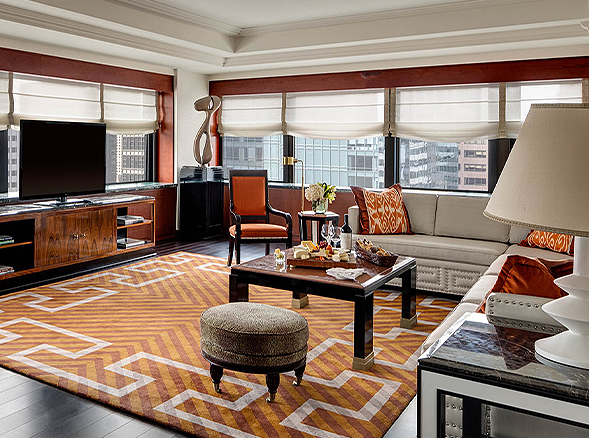 elegant living room with orange accent furniture and large windows