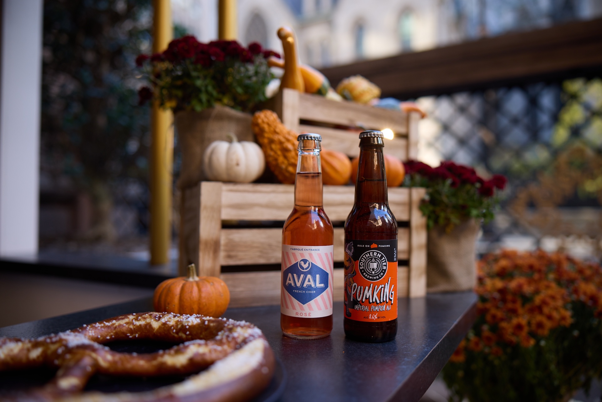 two bottles of beer next to a pretzel