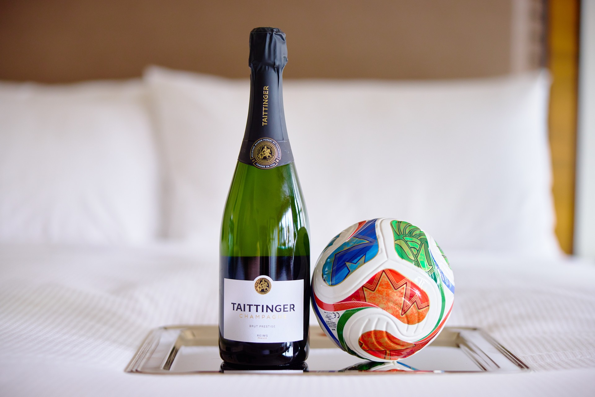 a bottle of champagne and a football ball on a tray