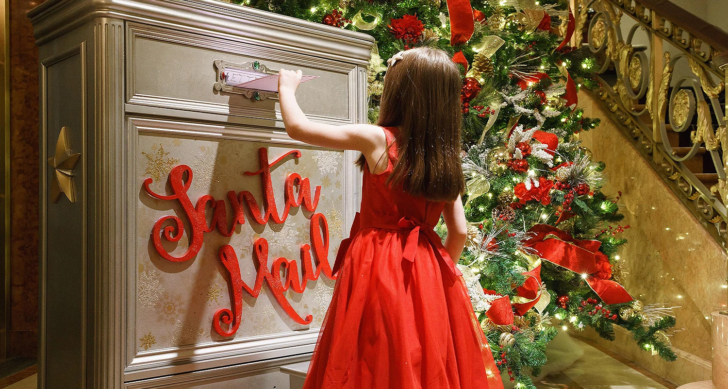 little girl putting letter in mailbox for santa
