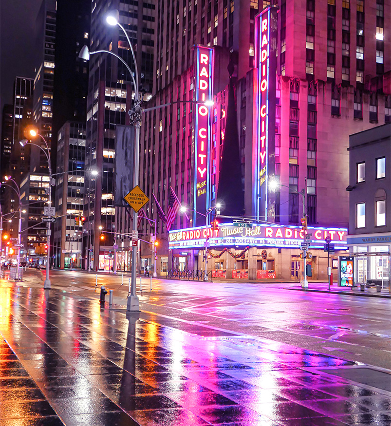 a wet street with buildings and neon signs