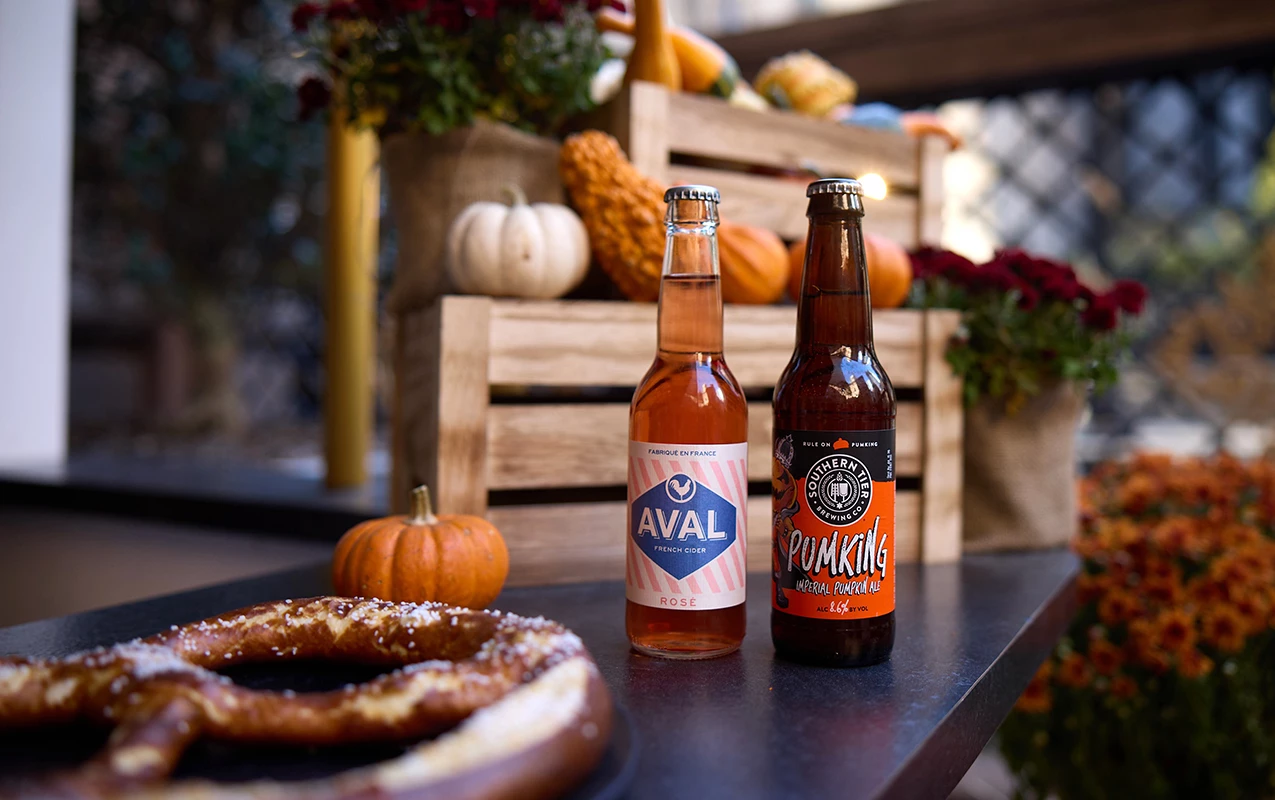 two bottles of beer next to a pretzel