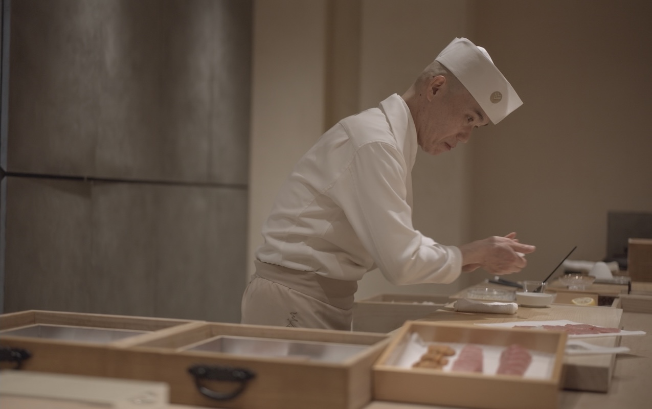 omakase sushi chef in white uniform making nigiri