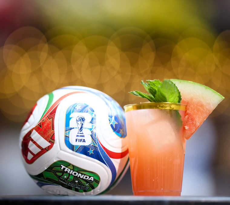 a glass of liquid next to a football ball