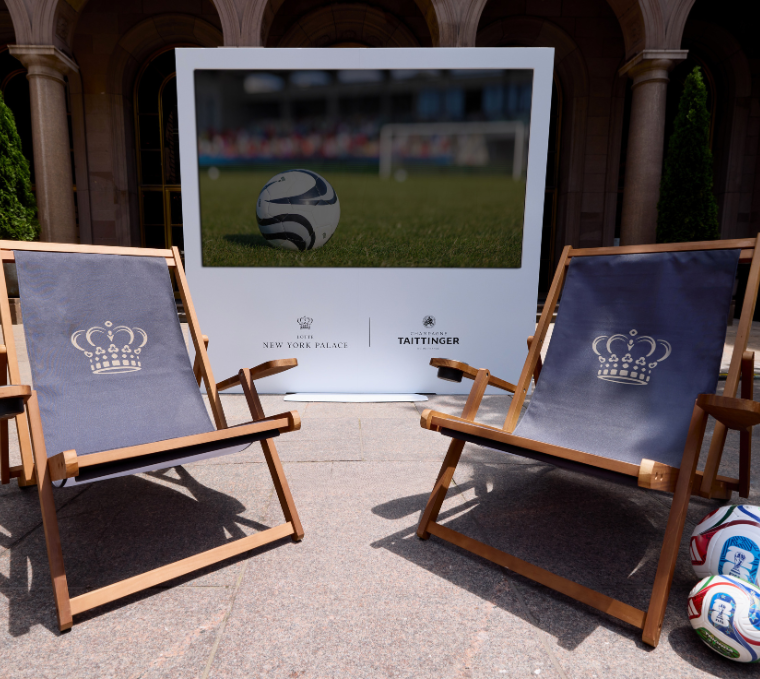 a pair of chairs with a football ball in front of a sign
