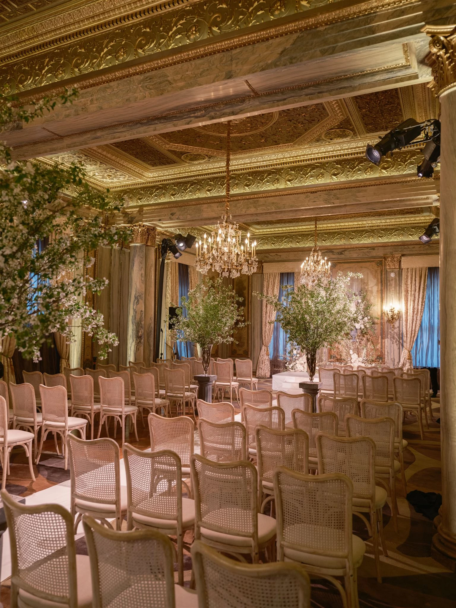 a room with chairs and chandeliers