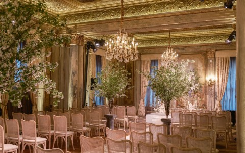 a room with chairs and chandeliers