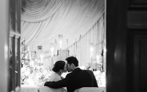 a man and woman kissing at a table