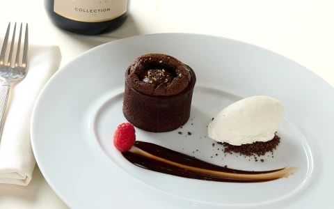 a plate of dessert with a raspberry and ice cream