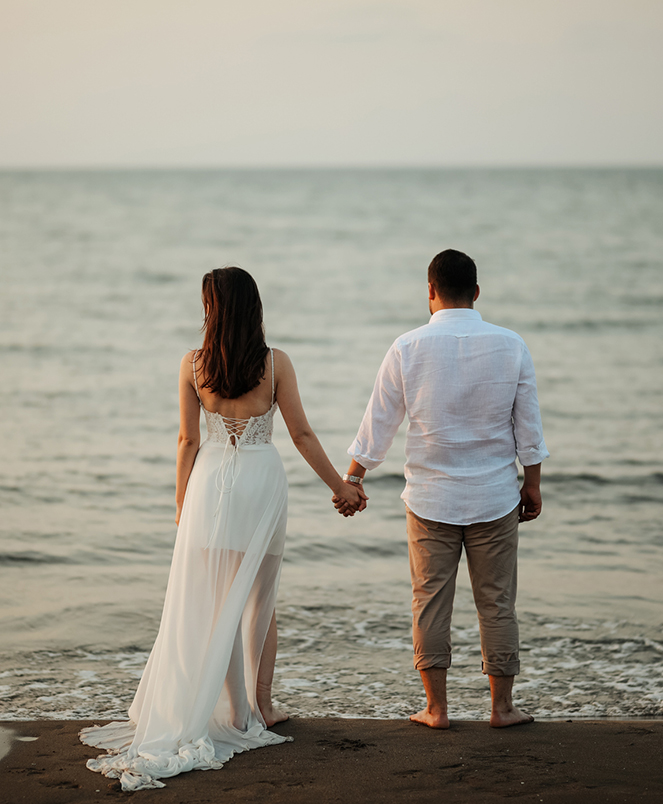 a man and woman holding hands on a beach