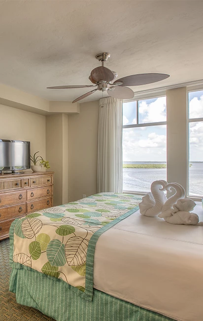 Room with king bed and tv on top of wooden dresser