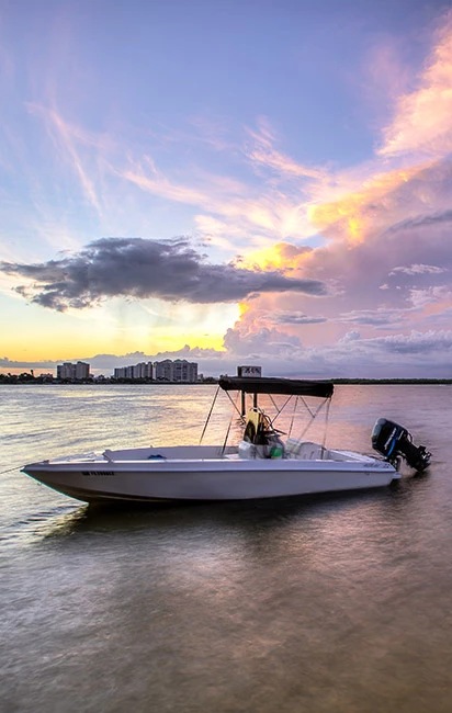 White yacht with sun setting in the back