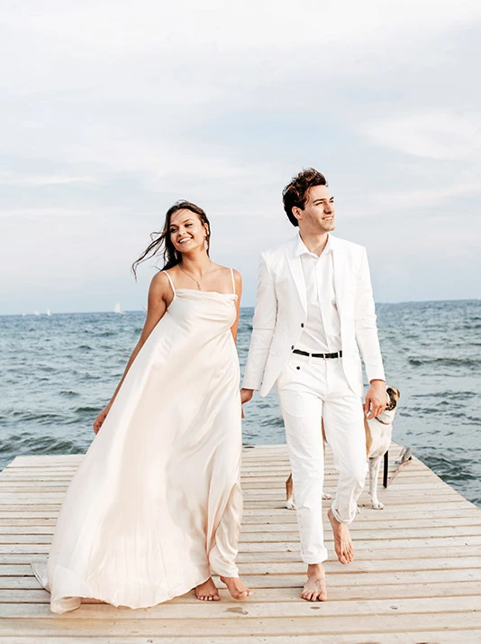 Wedding couple walking on wooden dock