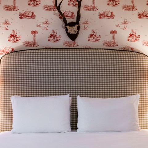 a bed with a headboard and a deer antler on the wall