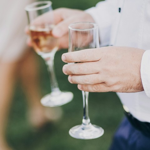 a person holding wine glasses