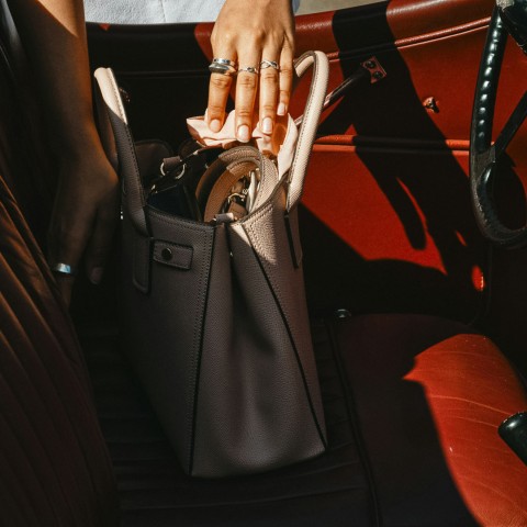 a hand holding a purse