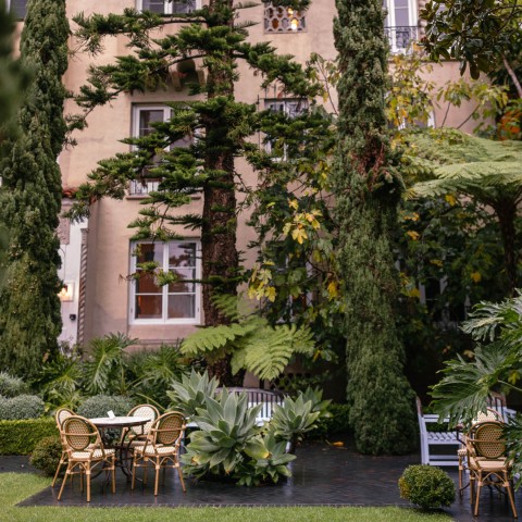 a patio with chairs and trees in the background