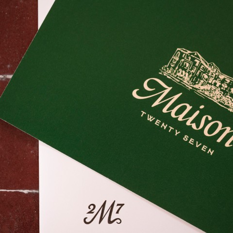 a green and white paper with a picture of a building