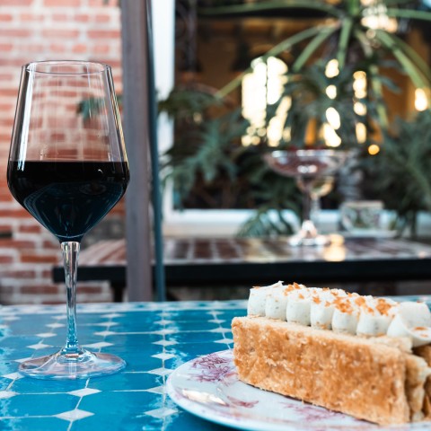 a glass of wine next to a plate of food