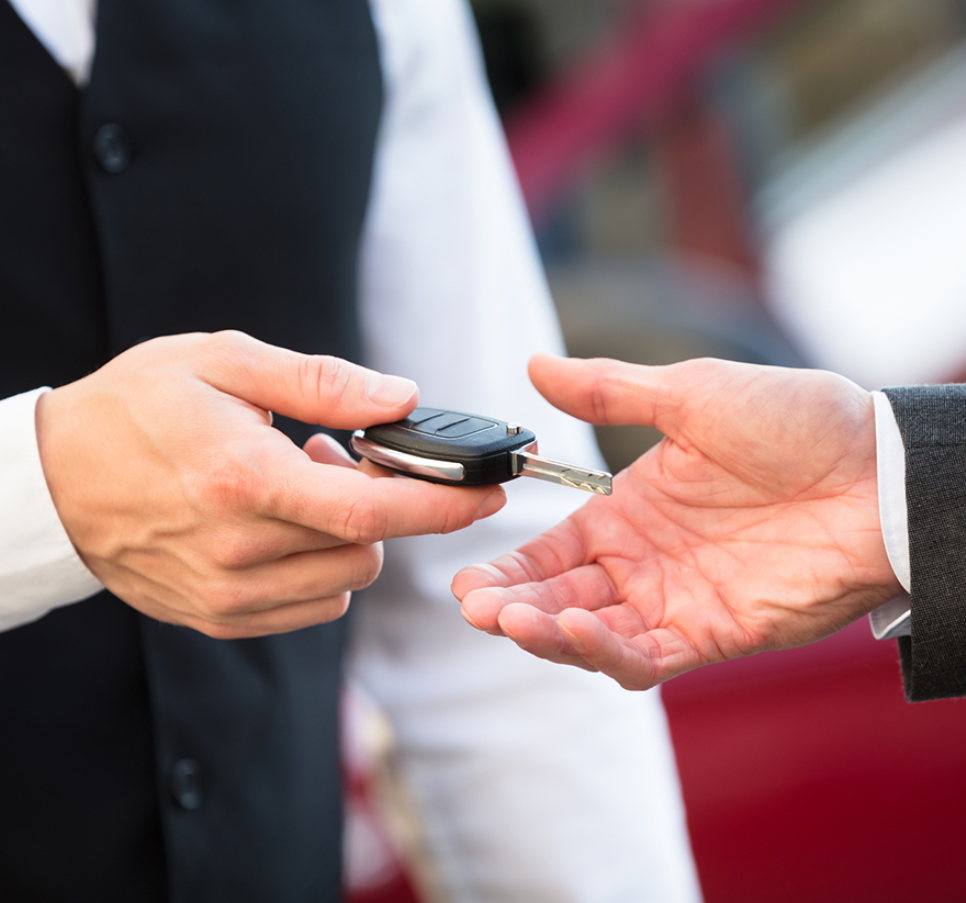 a person handing over a car key