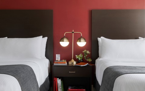 a two beds with a lamp on a table